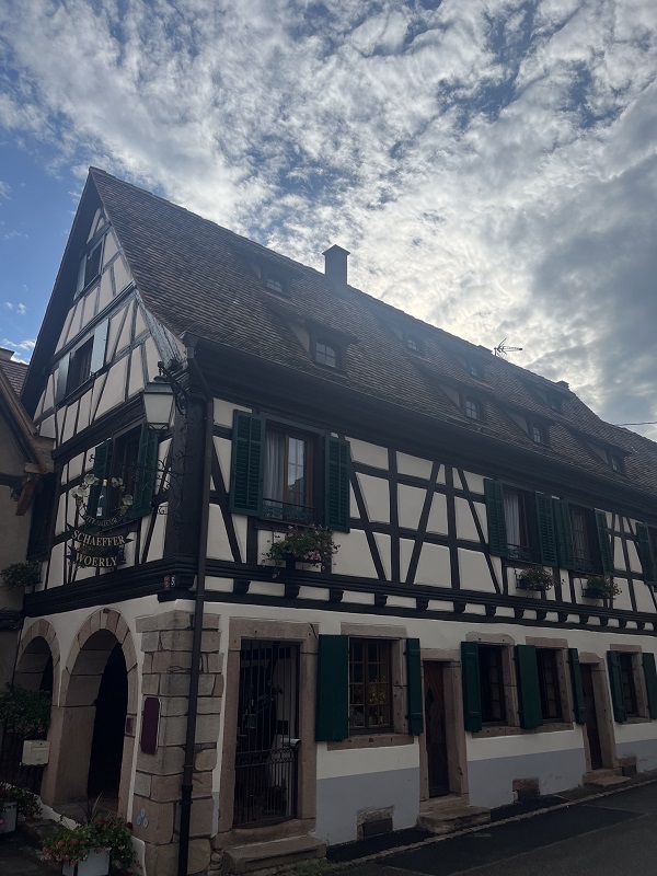 Elsässisches Haus der Domaine Schaeffer-Woerly in Dambach-la-Ville unter strahlend blauem Himmel.