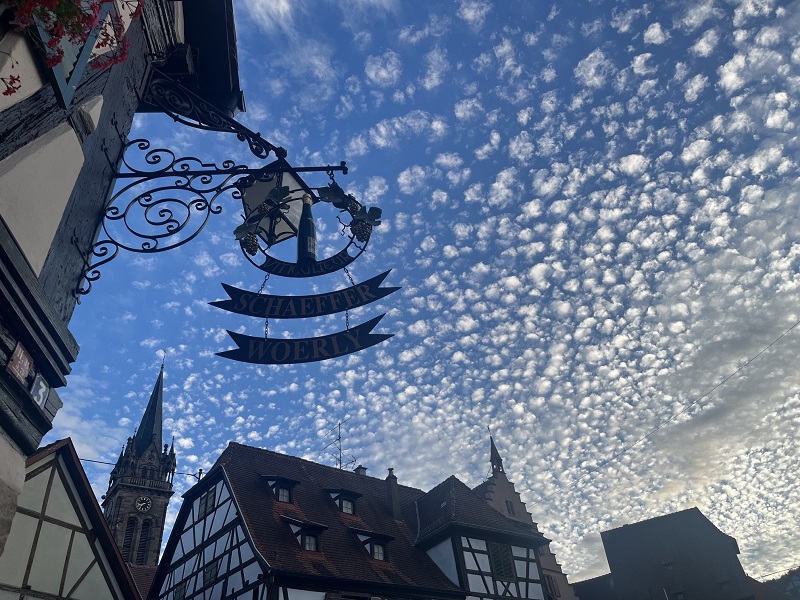 L'enseigne du Domaine Schaeffer-Woerly sous un superbe ciel bleu parsemé de nuages à Dambach-la-Ville.